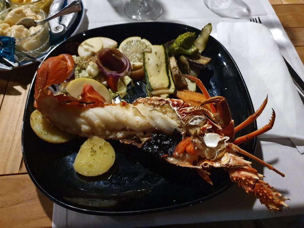 Aragosta fresca di giornata preparata e servita a bordo di una barca a vela durante una crociera di lusso.