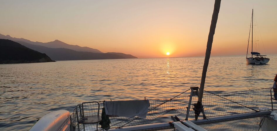 Catamaran and sailboat at breathtaking sunset anchorage. Boat rentals and Aeolian Islands cruises with MySailCruise skipper.