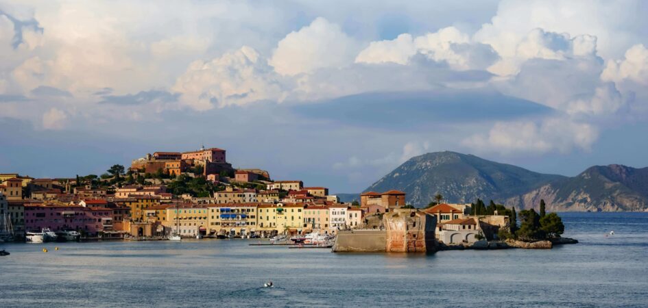 Magnifica vista del Golfo di Portoferraio all'Isola d'Elba, con fortificazioni storiche e un catamarano MySailCruise in rada.
