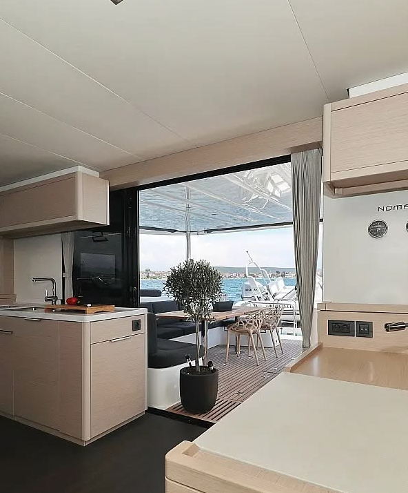 Open-plan living area connecting interior and outdoor spaces aboard a luxury catamaran – MySailCruise