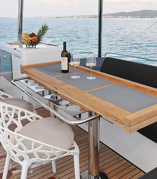 Outdoor dining area aboard a luxury catamaran with sea view – MySailCruise
